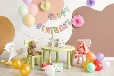 Balonlarla, oyuncaklarla ve mobilyalarla dolu bir doğum günü partisi.