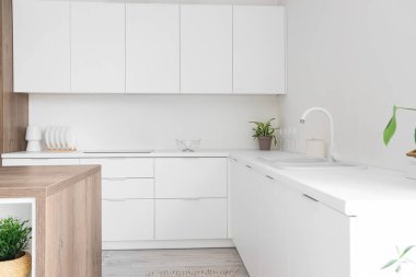 Beyaz tezgahlı aydınlık mutfağın içi.