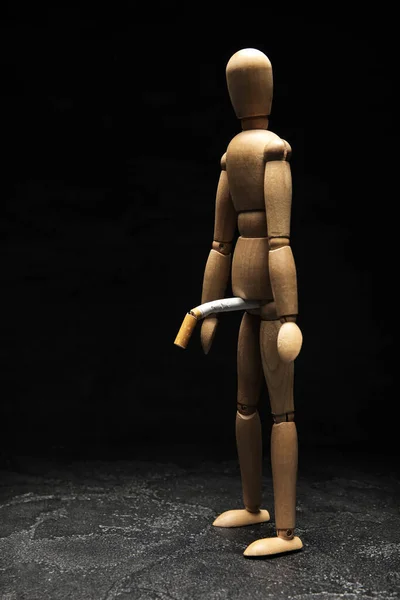 独创的构图 木制的人体模特和黑色背景的香烟 戒烟的概念 — 图库照片
