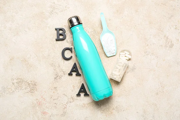 文字Bcaa 水のボトル アミノ酸の丸薬とグランジの背景に粉末 — ストック写真