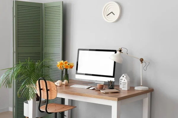 Stilvoller Arbeitsplatz Mit Modernem Und Narzissenblumen Nahe Lichtwand — Stockfoto