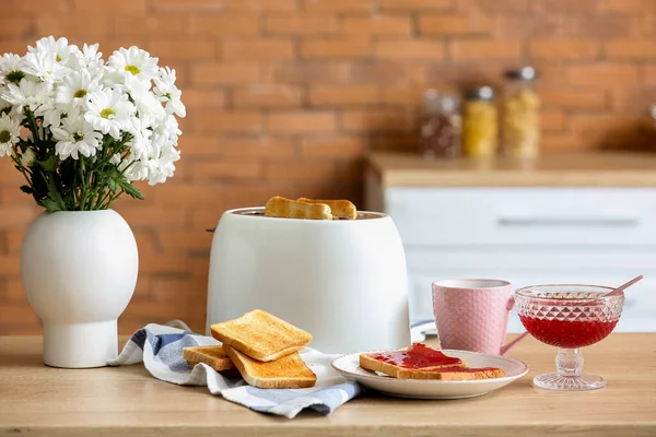 Stock image Modern toaster with crispy bread slices and sweet jam toasts on table in kitchen