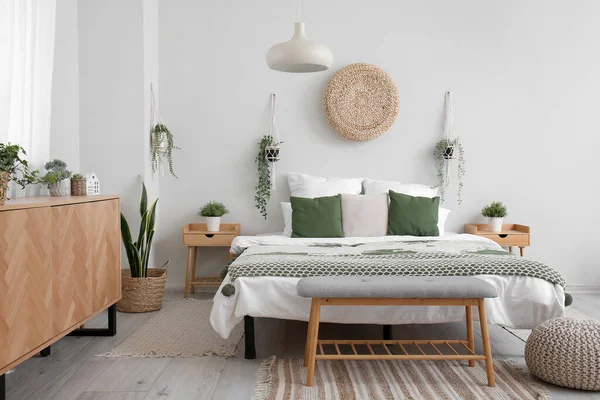 轻便卧室的内部 有舒适的床 木柜和挂着的室内植物 — 图库照片