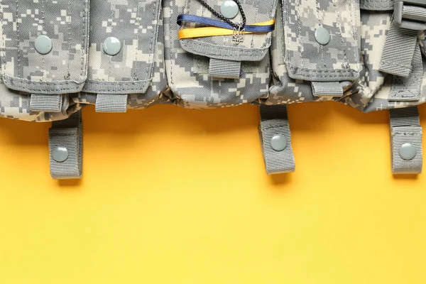 黄色の背景に腕 リボンと軍事バッグのウクライナのコートとチェーン クローズアップ — ストック写真