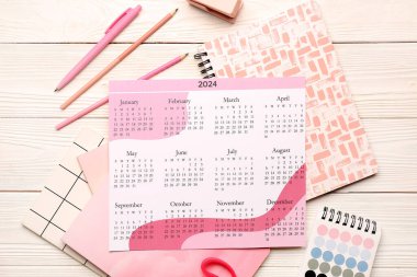 Calendar, notebooks, color palette and stationary on white wooden background clipart