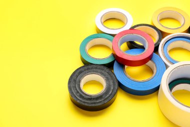 Sarı arkaplanda yapışkan bant ruloları