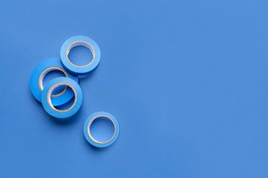 Mavi arkaplanda yapışkan bant ruloları