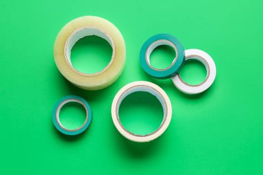 Yeşil arkaplanda yapışkan bant ruloları