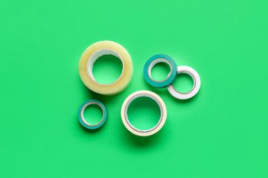 Yeşil arkaplanda yapışkan bant ruloları