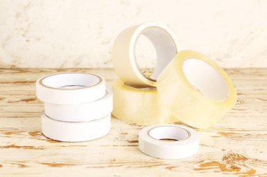 Yapıştırıcı bant açık tahta masada yuvarlanıyor.