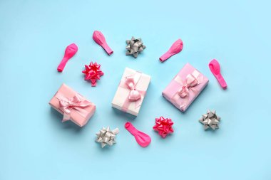 Soluk mavi arkaplanda doğum günü hediyesi kutuları ve balonları olan kompozisyon