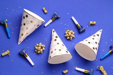 Parti şapkaları ve düdükler koyu mavi arka planda