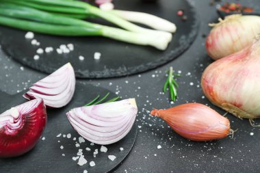 Grunge siyah arkaplanda farklı soğan çeşitleri olan tahtalar