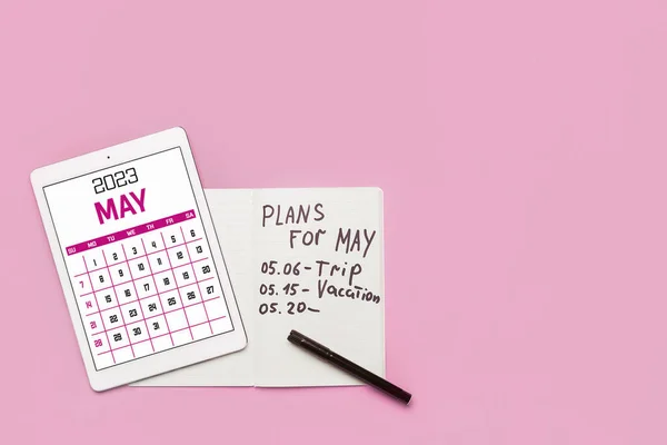 带有日历和笔记本电脑的现代平板电脑 计划于5月在粉色背景上运行 — 图库照片