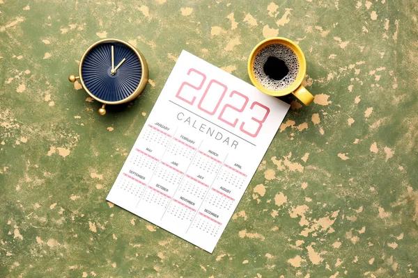 绿色桌子上的日历 闹钟和一杯咖啡 — 图库照片