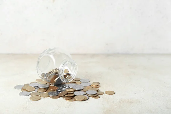 ベージュのグランジテーブルのコインで裏返しの瓶 貯蓄概念 — ストック写真