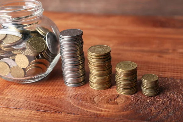 ジャーと木製の背景にコインのスタック 貯蓄概念 — ストック写真