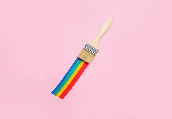 Paint brush with adhesive tapes on pink background