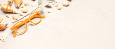 Açık arkaplanda deniz kabuğu ve metin için yeri olan şık gözlükler