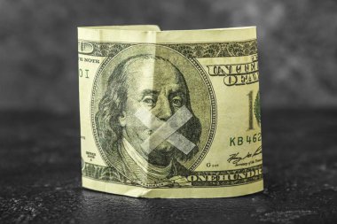 Karanlık masanın üzerine bantlanmış dolar banknotu. Sansür kavramı