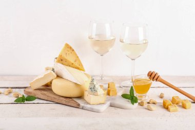 Farklı çeşitlerde lezzetli peynir, bal ve şarap.