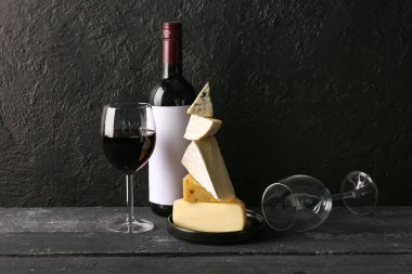 Farklı lezzetli peynirler, bardaklar ve şarap dolu şişeler.