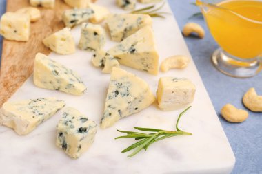 Masada lezzetli peynir parçaları olan tahta, yakın plan.