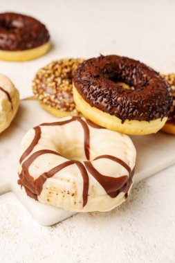 Hafif arkaplanda çikolatalı donutlar olan tahta.