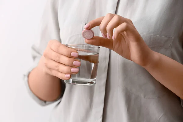 Kadın Beyaz Arka Planda Çözünür Tableti Bir Bardak Suya Koyuyor — Stok fotoğraf