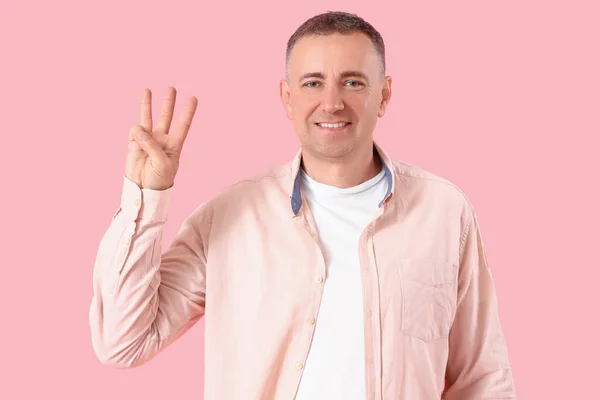 Mature Blood Donor Showing Three Fingers Pink Background — Stock Photo, Image