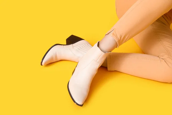 黄色の背景にスタイリッシュな靴の女性の足 — ストック写真