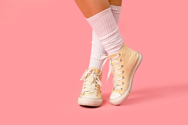 粉红背景的时髦胶鞋女腿 — 图库照片