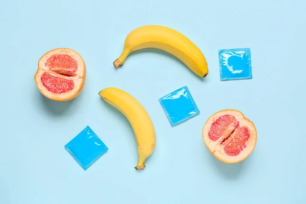 Banány Nakrájeným Grapefruitem Kondomy Modrém Pozadí Pohlavní Koncept — Stock fotografie