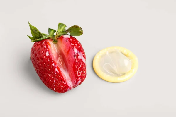 Erdbeere Mit Milchtropfen Und Kondom Auf Hellem Hintergrund Sexualkonzept — Stockfoto