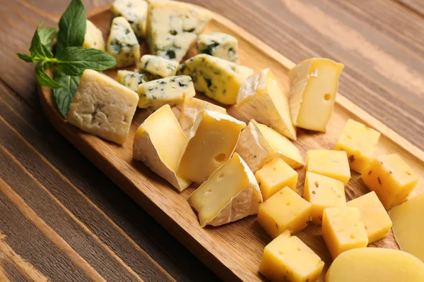 板子上有木制背景的美味奶酪 — 图库照片