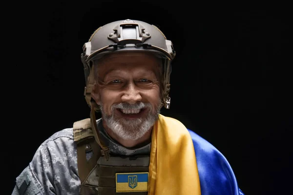 stock image Happy mature soldier with Ukrainian flag on black background, closeup