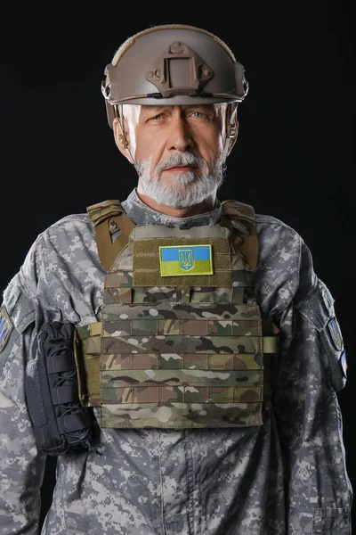 黒の背景にウクライナのパッチを持つ熟女兵士 — ストック写真