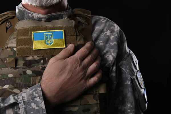 黒の背景にウクライナのパッチを持つ成熟した兵士 クローズアップ — ストック写真