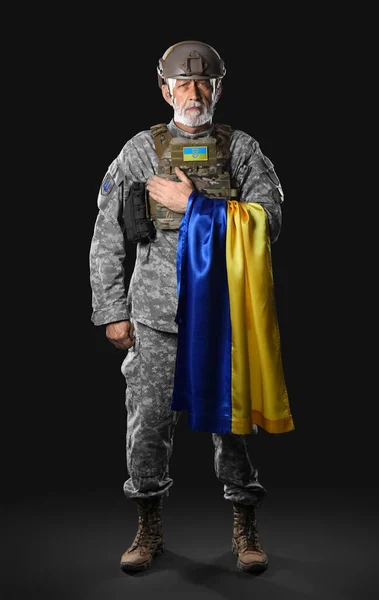 黒の背景にウクライナの旗を持つ熟女兵士 — ストック写真