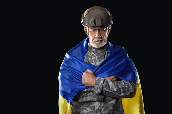 黒の背景にウクライナの旗を持つ熟女兵士 — ストック写真