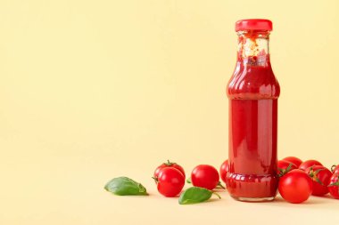Bej arka planda cam ketçap ve domates şişesi.