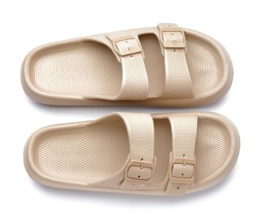 Beyaz arkaplanda şık bej parmak arası terlikler.