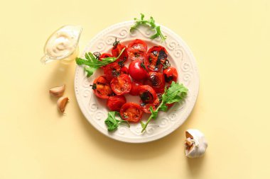 Lezzetli ızgara domates ve sarı arka planda roka.