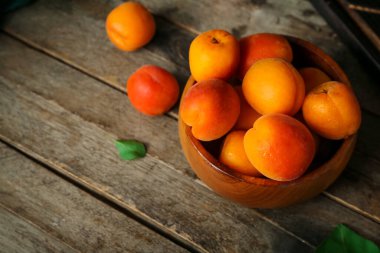 Ahşap masa üzerinde taze kayısı ile kase