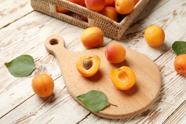 Tahta ve hasır kutu beyaz ahşap arka planda taze kayısılar