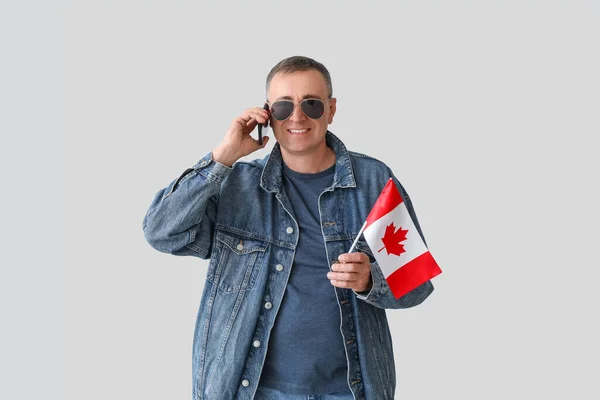 Dojrzały Mężczyzna Flagą Kanady Mówi Przez Telefon Komórkowy Tle Światła — Zdjęcie stockowe
