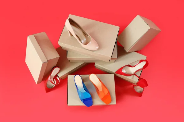 Cardboard Boxes Different Stylish High Heeled Shoes Red Background — Stock Photo, Image