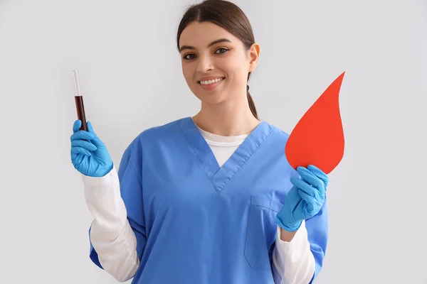 Krankenschwester Mit Reagenzglas Und Papierbluttropfen Auf Hellem Hintergrund — Stockfoto
