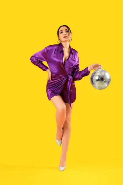 Модная Красивая Женщина Элегантном Фиолетовом Платье Дискотекой Позирующей Желтом Фоне — стоковое фото