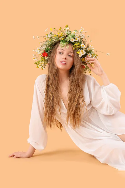 ベージュの背景に花の花輪の美しい若い女性 — ストック写真
